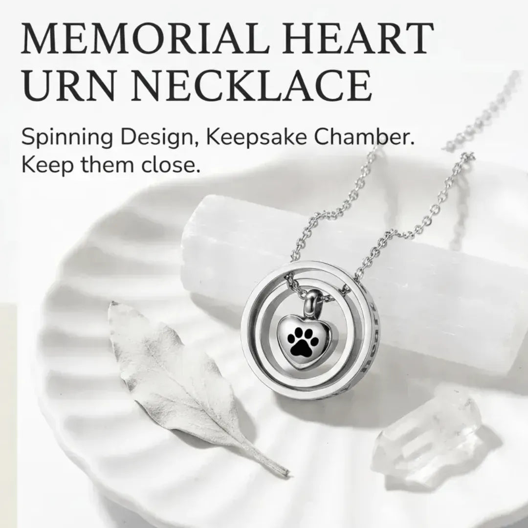 Memorial heart urn necklace with paw design on a white surface