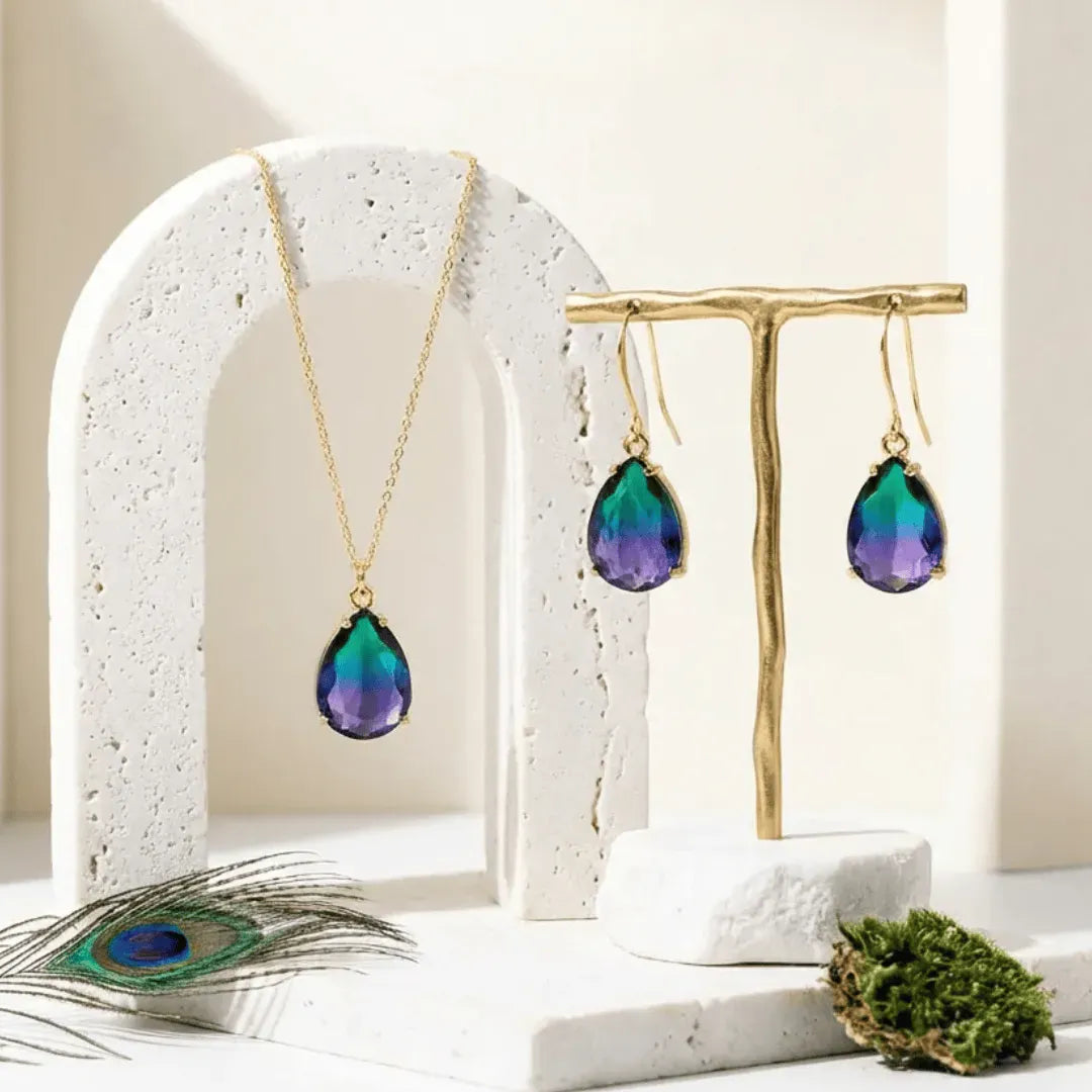 Jewelry set with necklace and earrings on a decorative stand with peacock feather and moss.