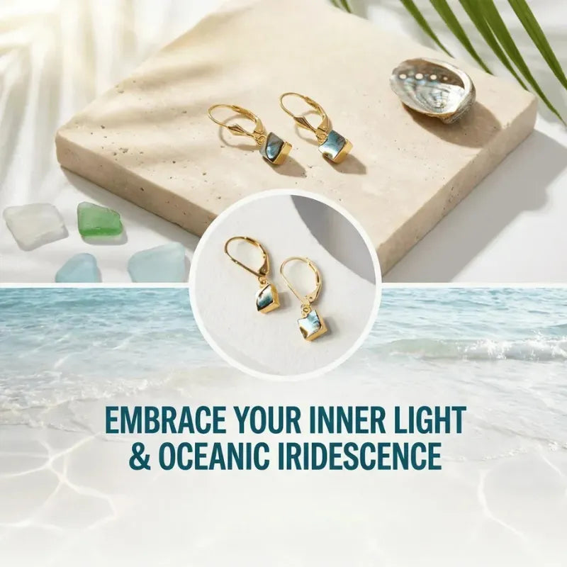 Gold earrings with oceanic iridescence on a beach-themed background