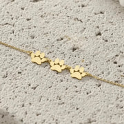 Gold paw print bracelet on a textured surface