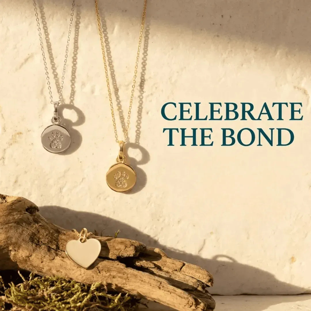 Two gold necklaces with paw print pendants on a natural background with text 'Celebrate the Bond'.