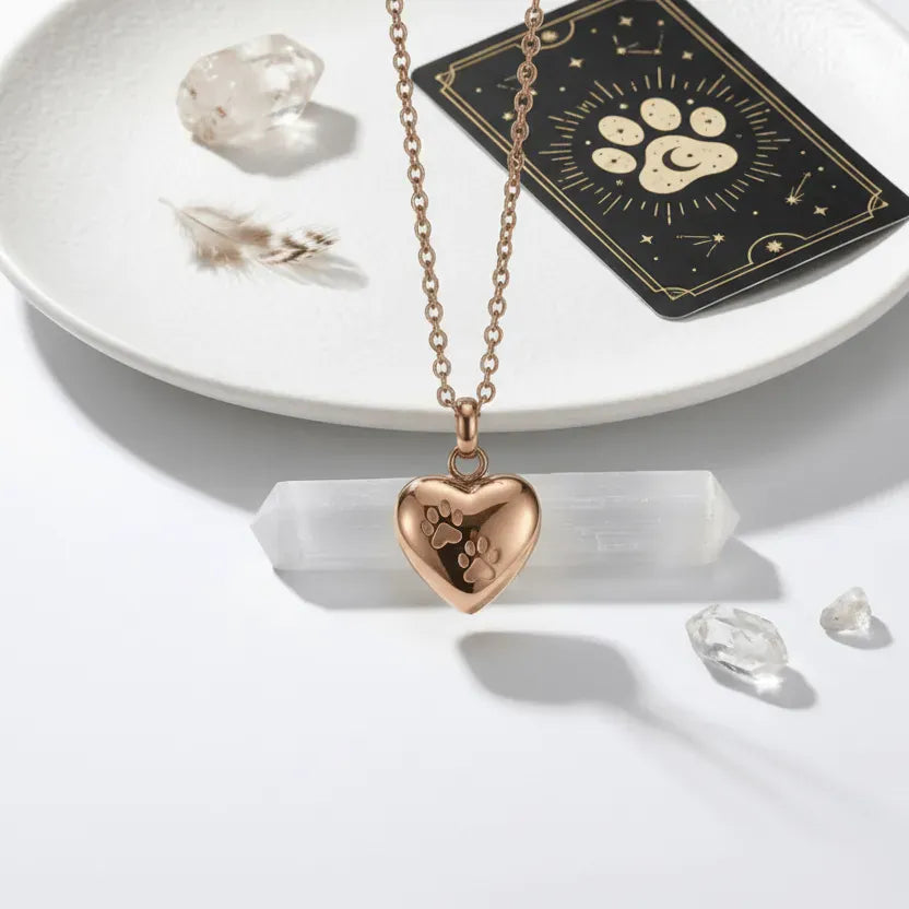 gold necklace with heart pendant on a white dish with crystals and tarot card