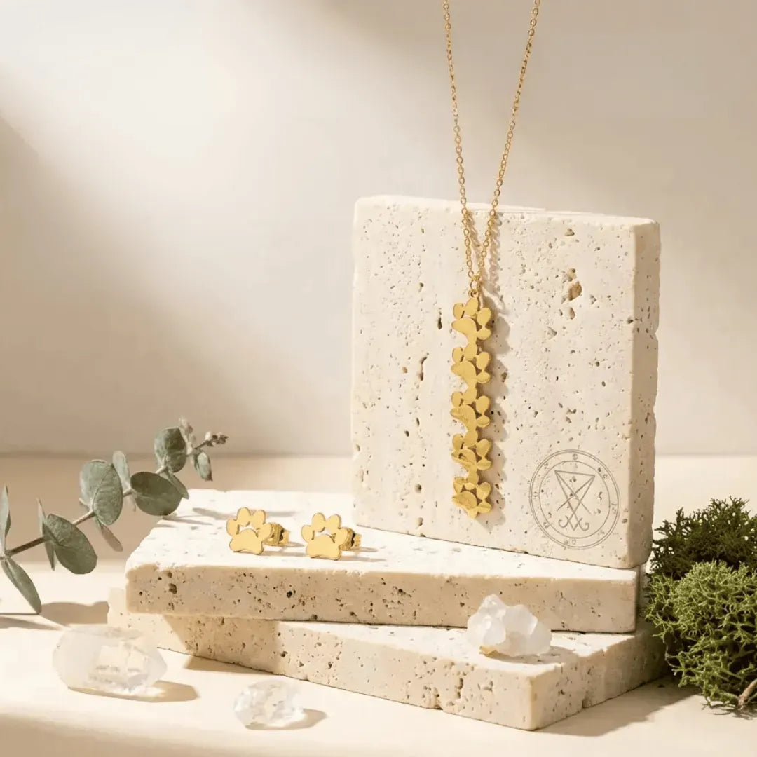 Gold jewelry set on a stone display with a natural background