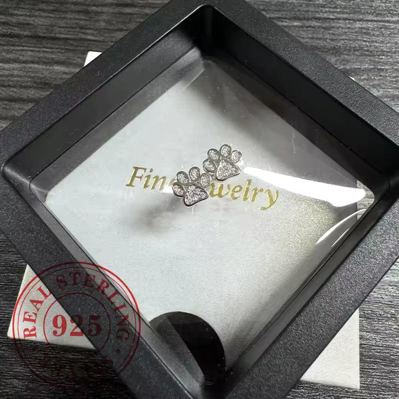 Jewelry box with a diamond-studded paw print earring inside, labeled 'Fine Jewelry'.