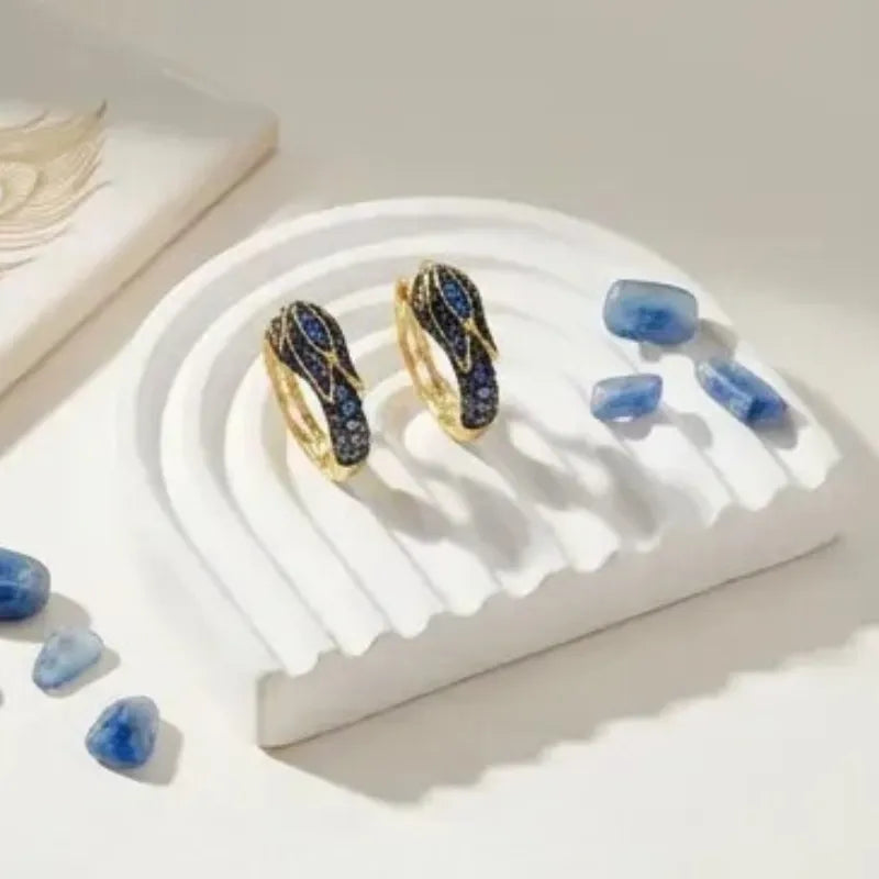 Gold rings with blue gemstones on a white stand