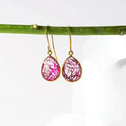 Teardrop-shaped earrings with pink and gold design on a white background