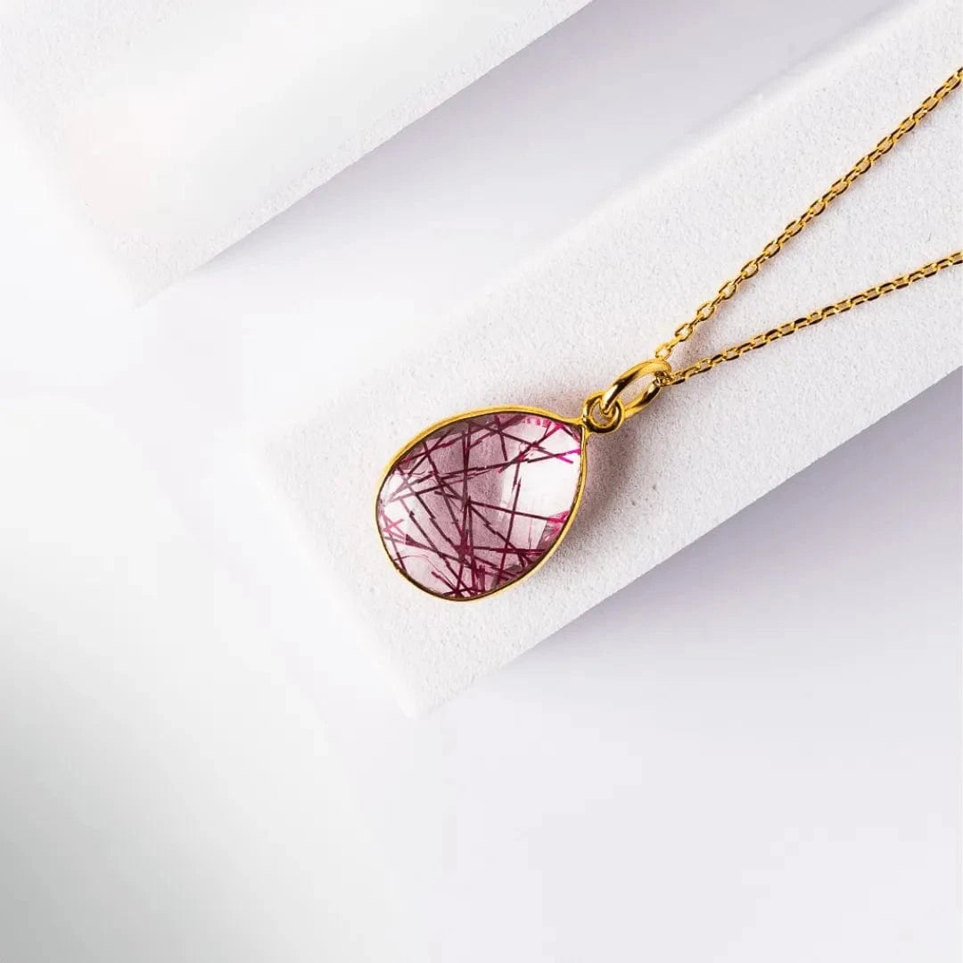 Necklace with a teardrop-shaped pink pendant on a white background