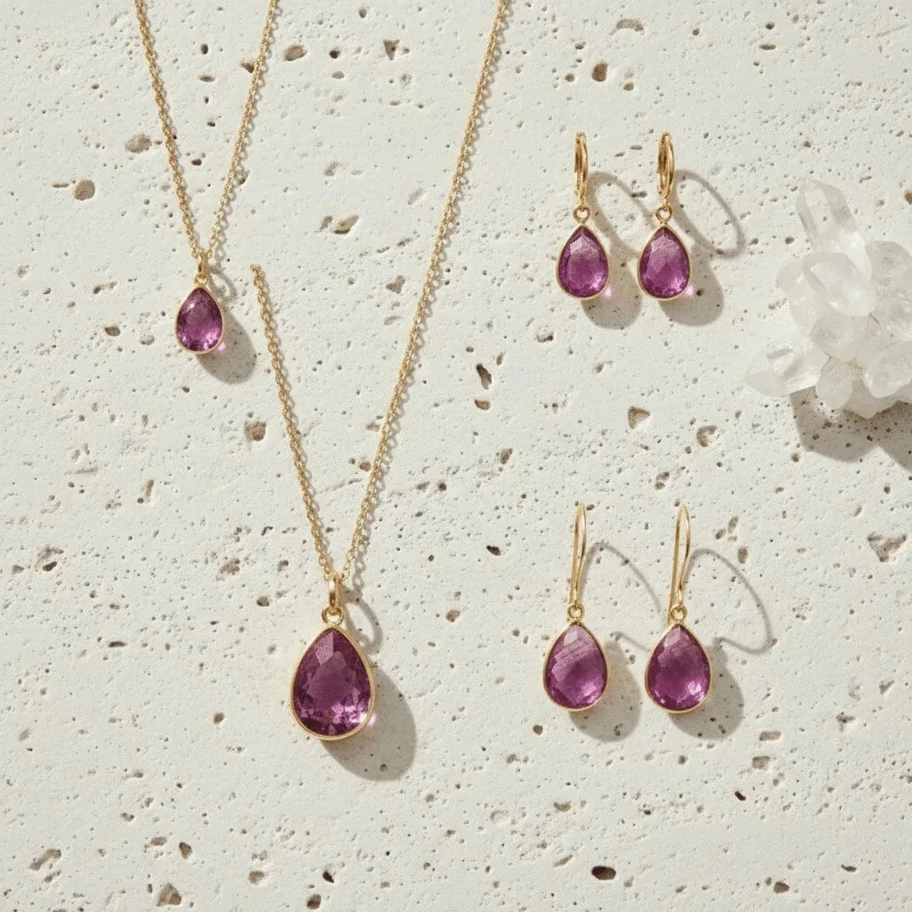 Jewelry set with pink teardrop-shaped gemstones on a white background