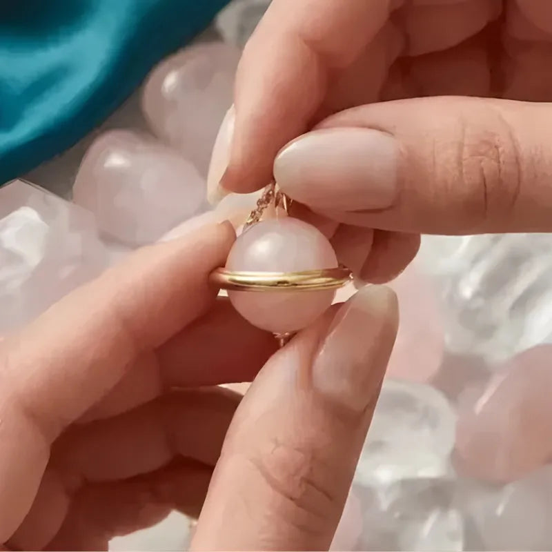 Close-up of hands holding a pearl necklace with a blurred background