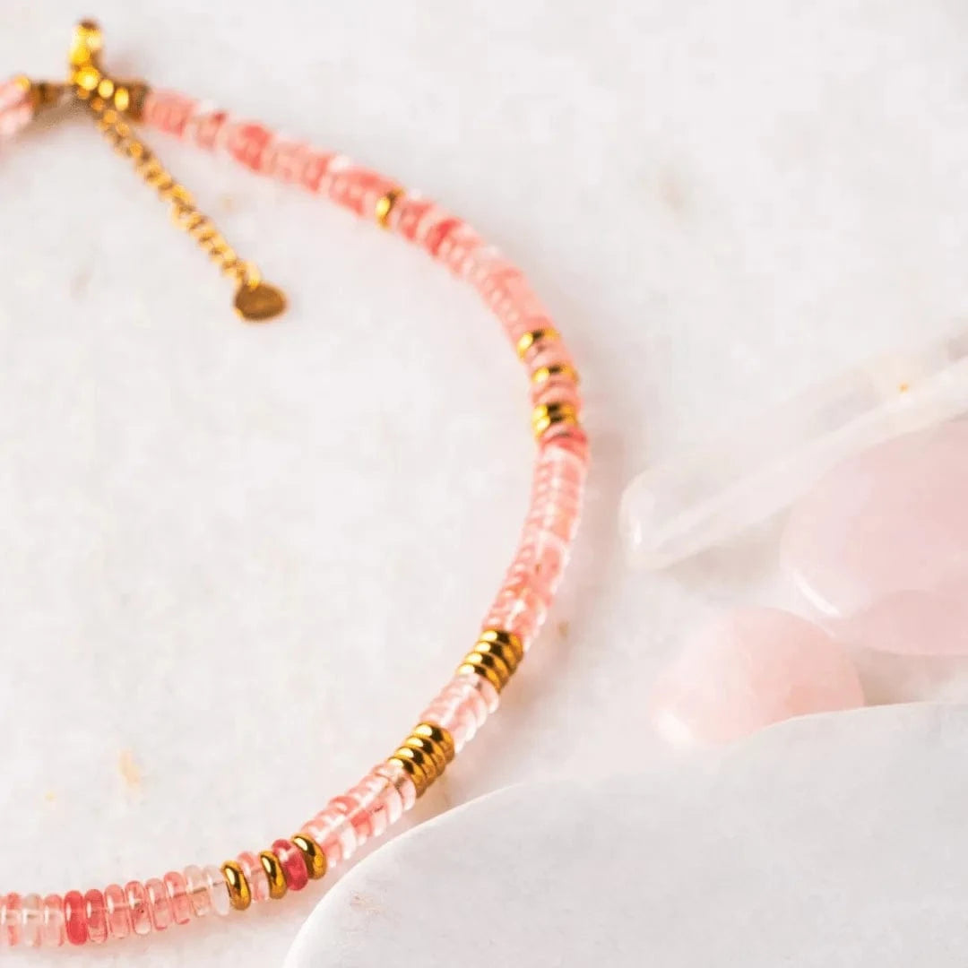 Necklace with pink and gold beads on a light background