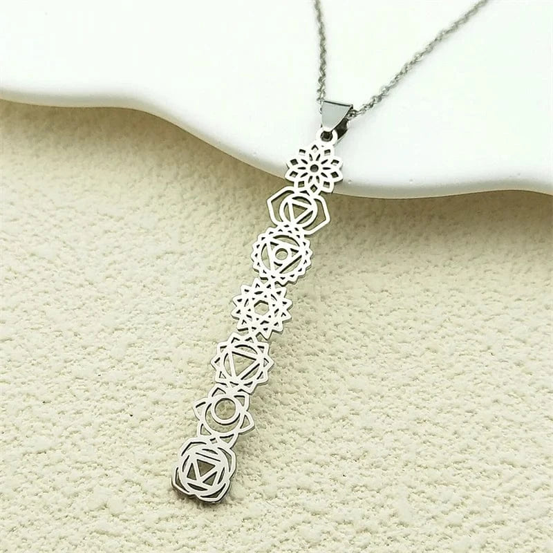Silver necklace with geometric pendant on a textured beige surface
