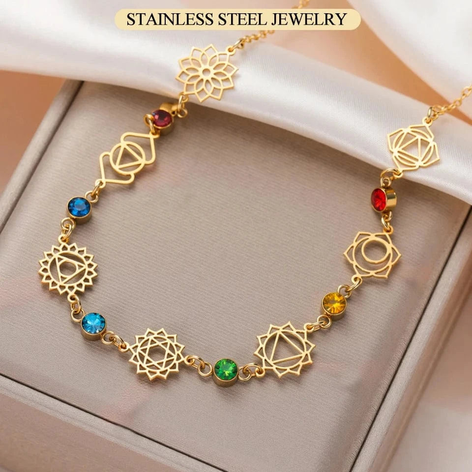 Gold necklace with colorful gemstones on a beige surface