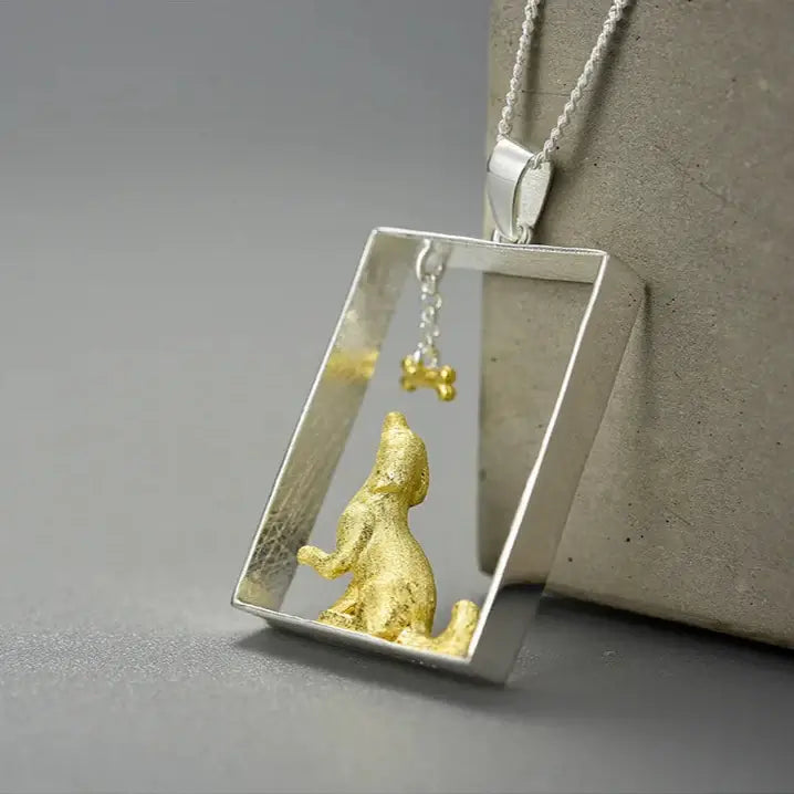 Sterling silver dog portrait pendant with gold detail, featuring a dog and a bone charm, elegant pet jewelry.