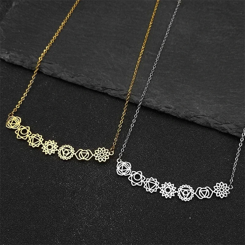 Two necklaces, one gold and one silver, on a dark surface