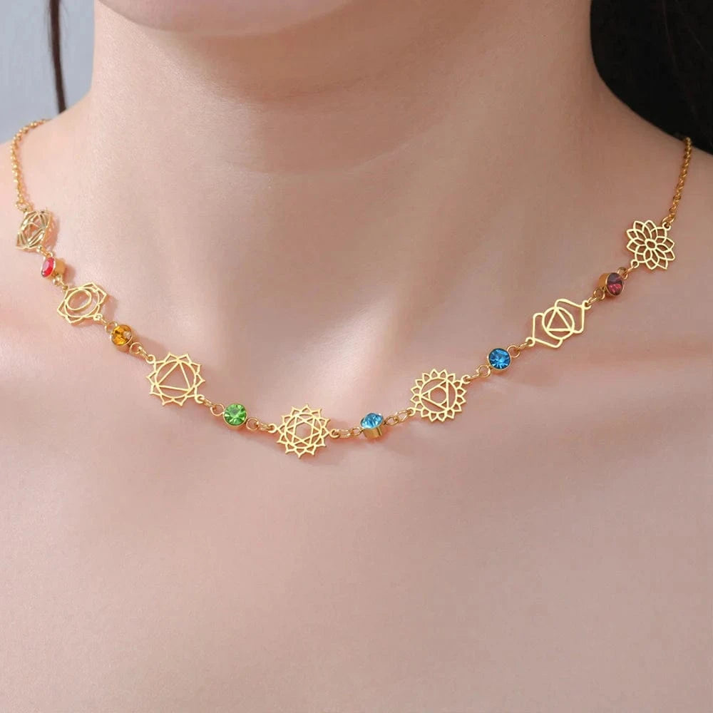 Gold necklace with colorful gemstones on a model against a neutral background
