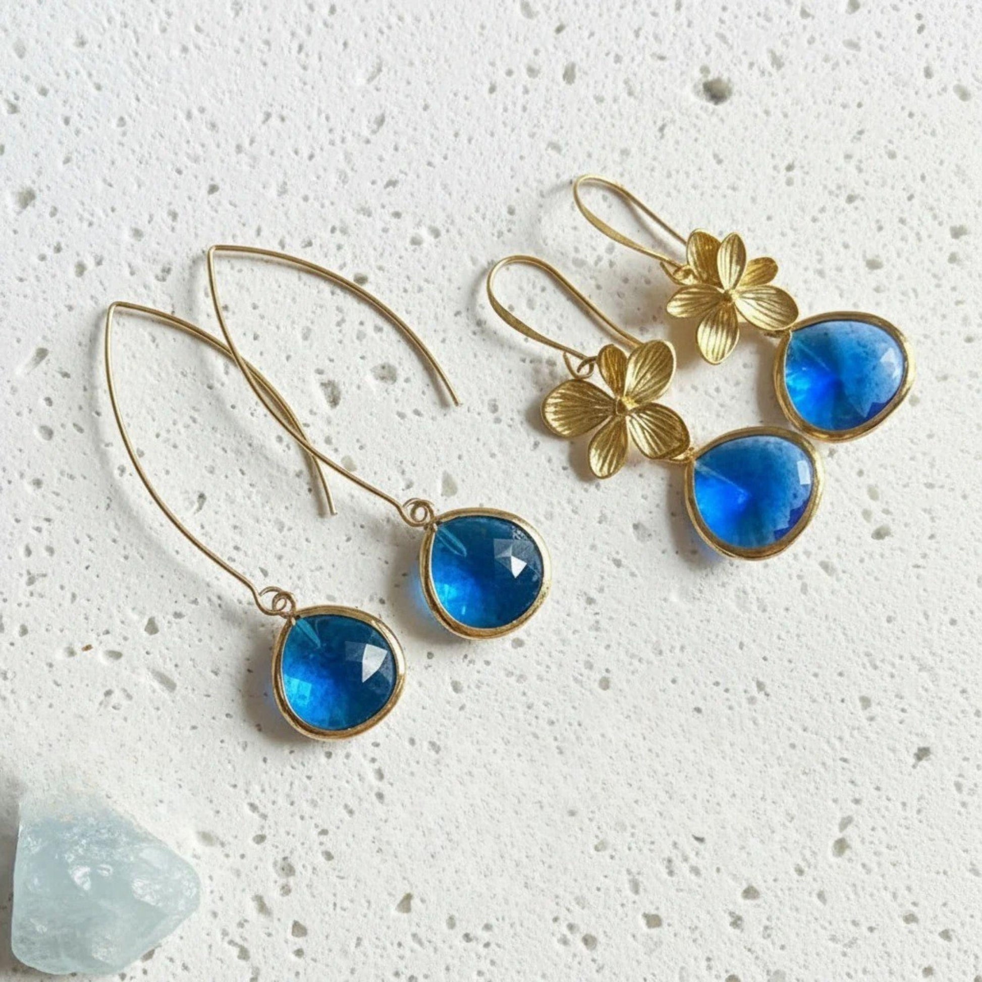 Sapphire Elegant Pebble earrings in gold styled with the single-bloom plumeria earrings