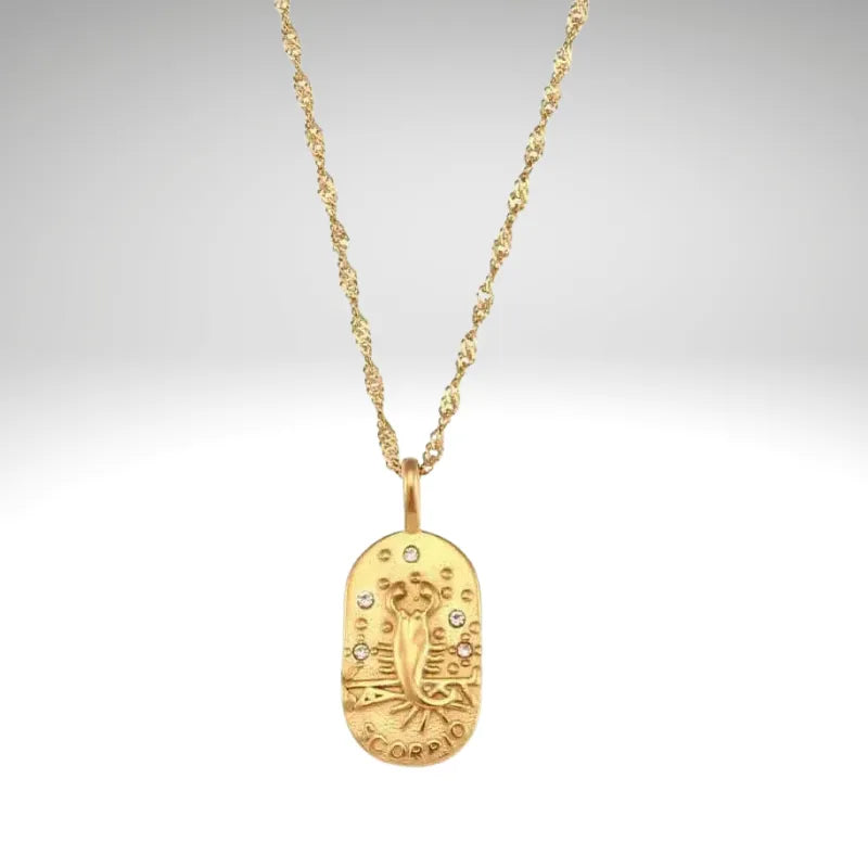 Gold necklace with a detailed pendant on a light gray background