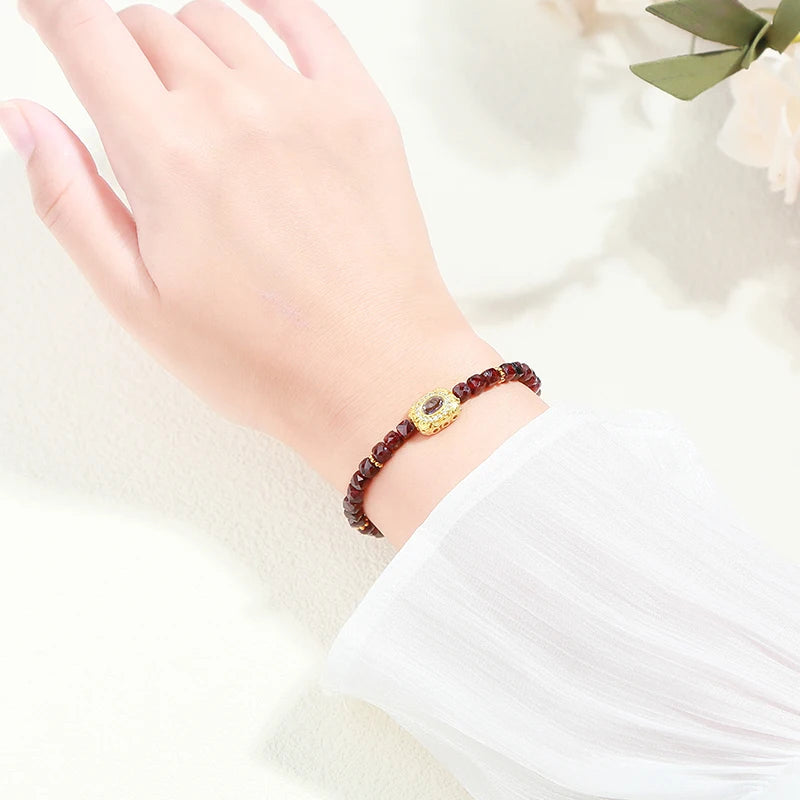 Faceted garnet bead bracelet on the wrist — January birthstone crystal jewelry for grounding