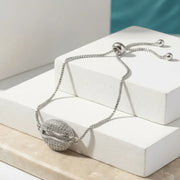 Silver bracelet with a round, ball-like clasp on a white surface