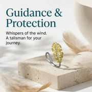 Gold leaf ring on a stone surface with text about guidance and protection.