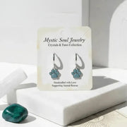 Turquoise paw print earrings on a 'Mystic Soul Jewelry' card with a white background
