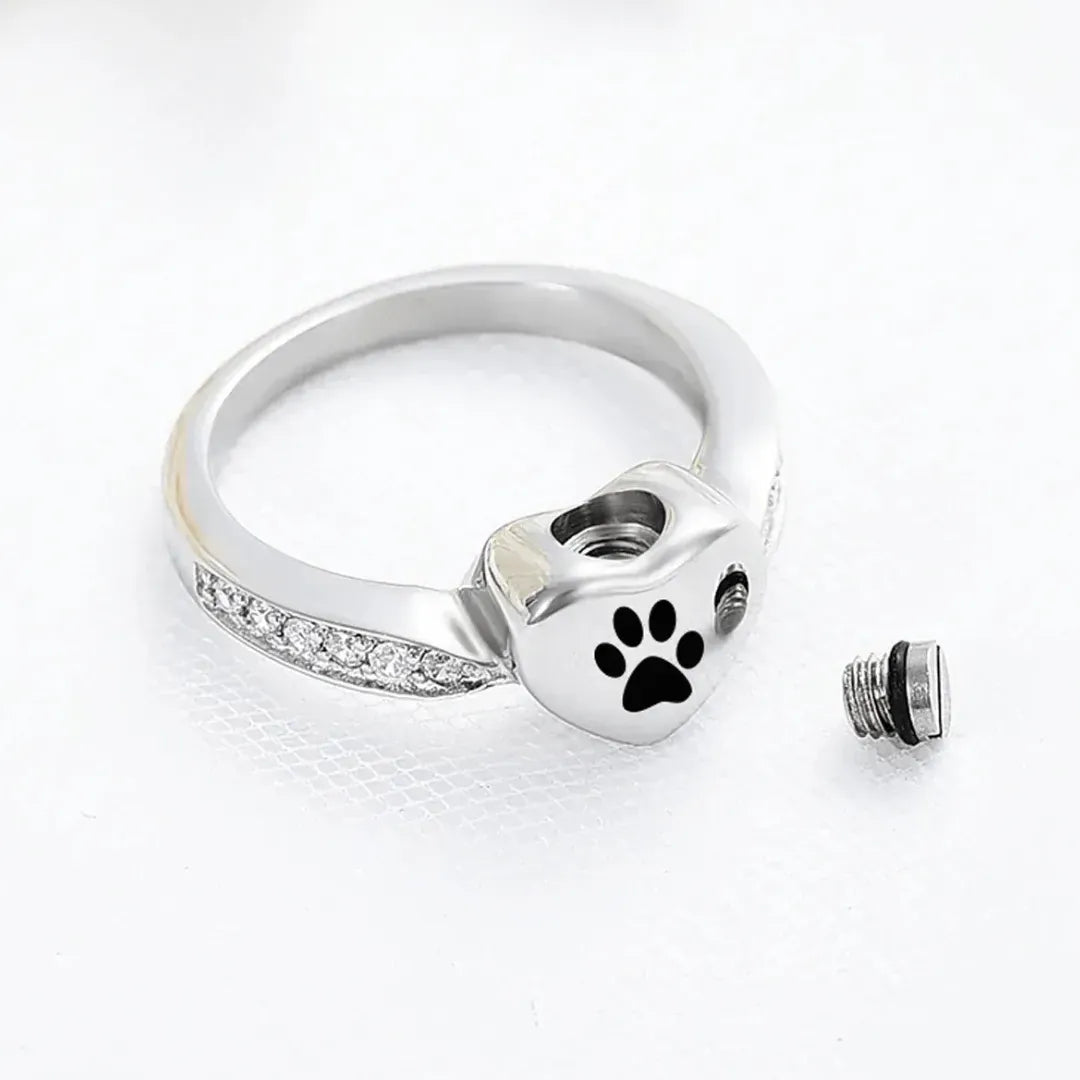 Silver ring with paw print design on a white background