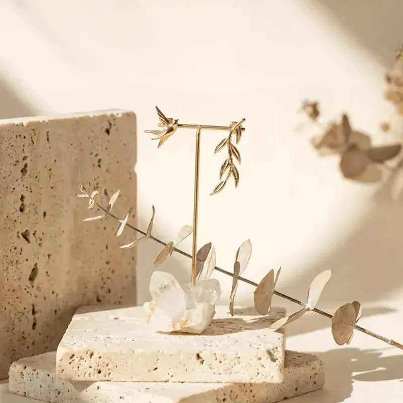 Decorative arrangement with crystal and branches on stone blocks against a neutral background