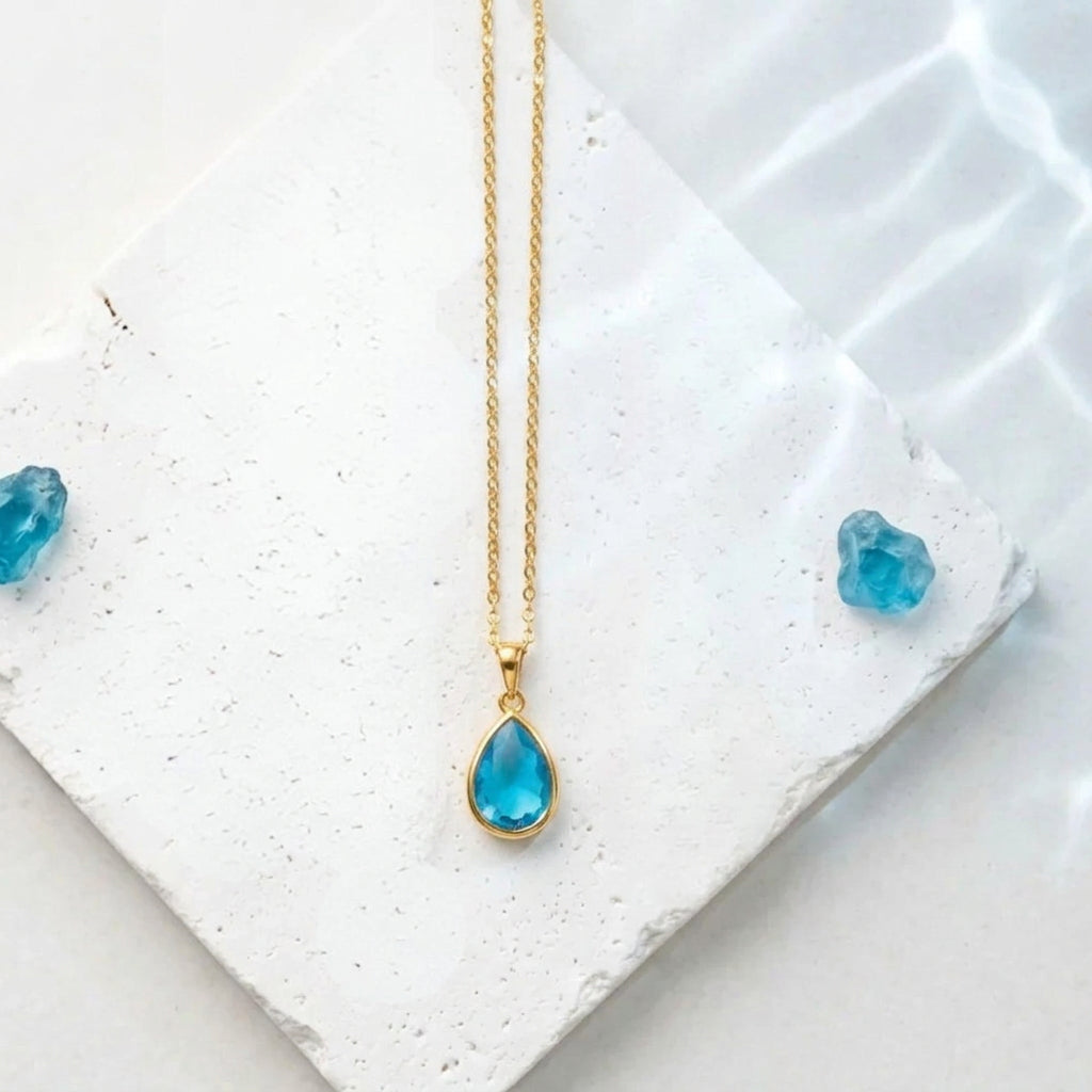 Gold teardrop pendant necklace with Capri blue faceted glass drop
