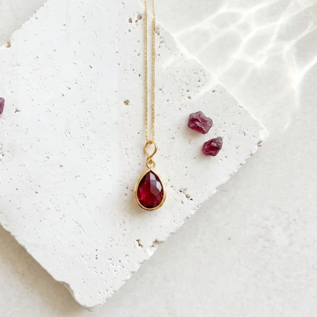 Gold teardrop pendant necklace with ruby red faceted glass drop, July birthstone colour