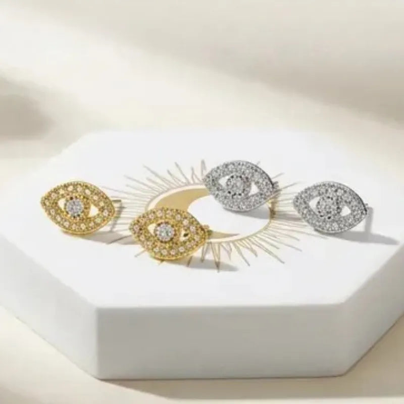 Pair of decorative earrings on a white stand with a soft beige background