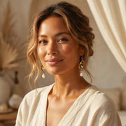 Woman wearing gold tiger eye drop earrings — solar plexus chakra jewelry for confidence
