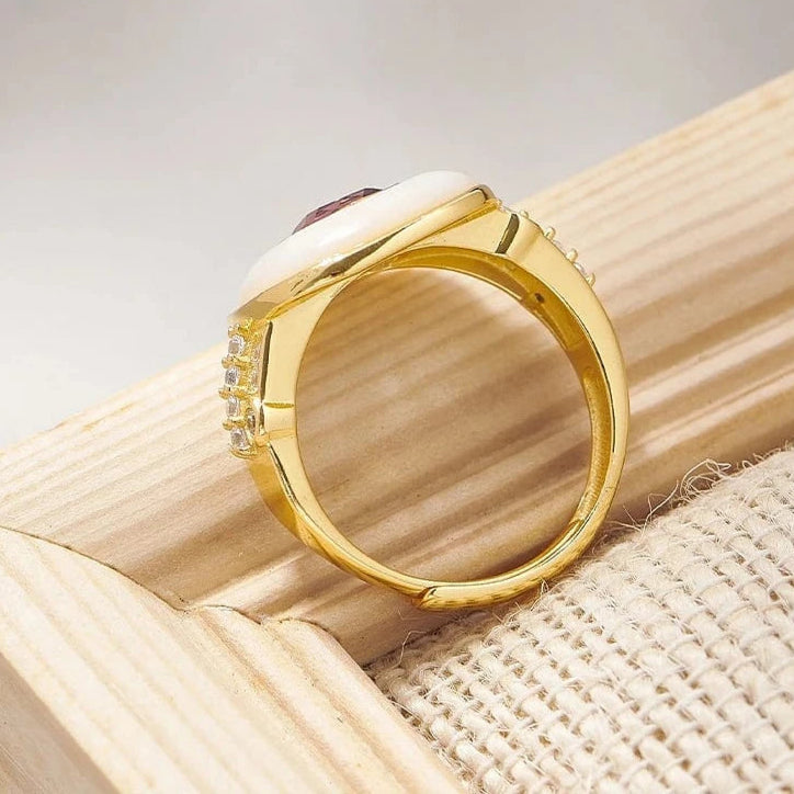 Gold ring with a gemstone on a wooden surface