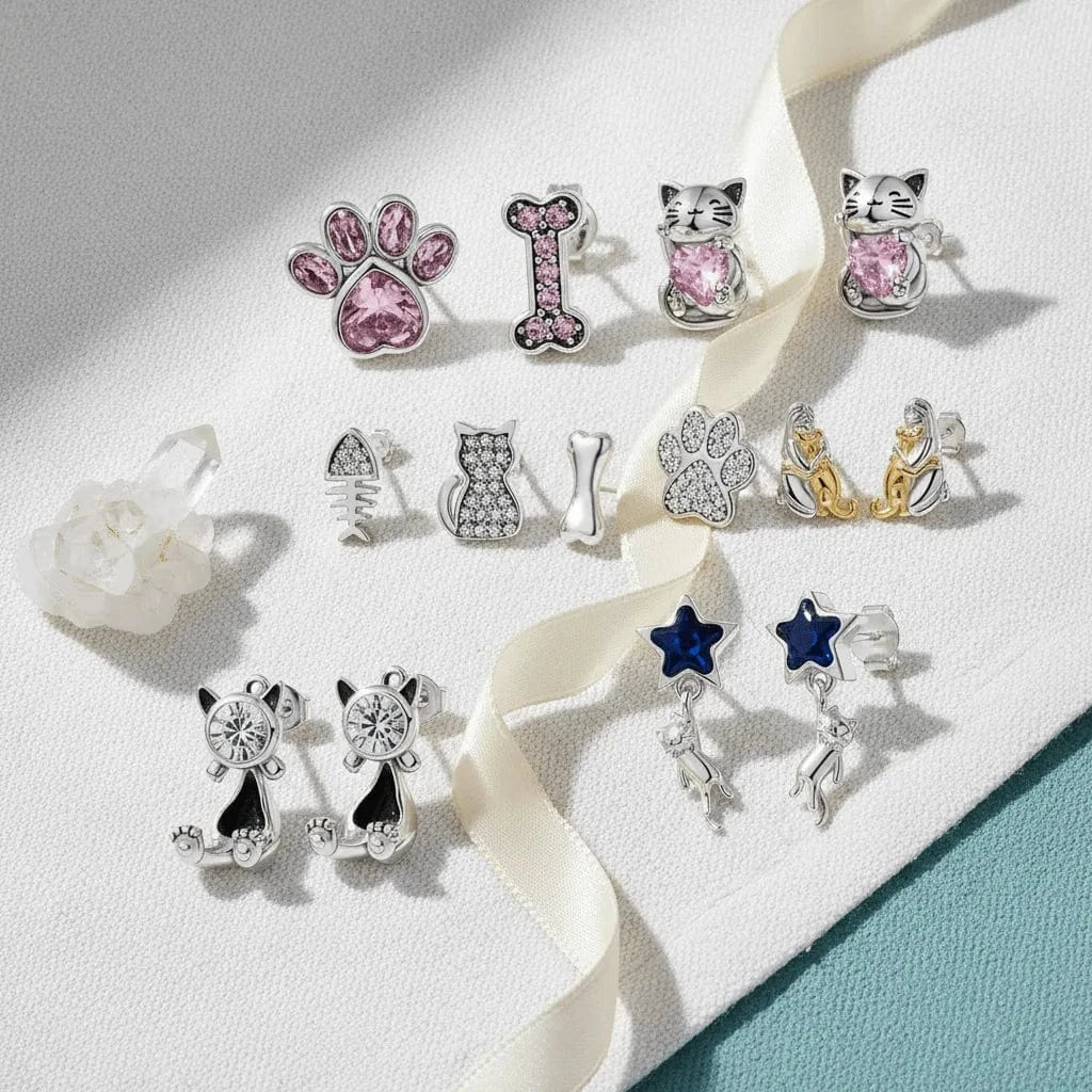 Collection of cat-themed earrings on a white background with a ribbon.