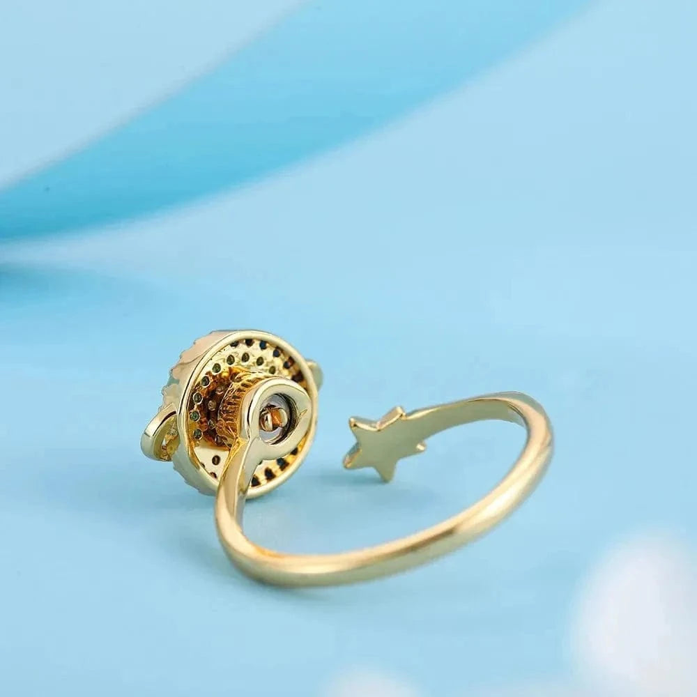 Gold ring with star design on a light blue background