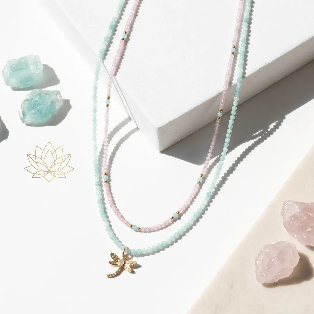 Necklace with a gold leaf charm on a light surface with crystals