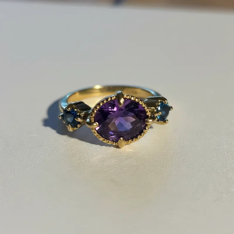 Close-up of the amethyst and blue topaz ring, purple and pale blue stones in gold plated sterling