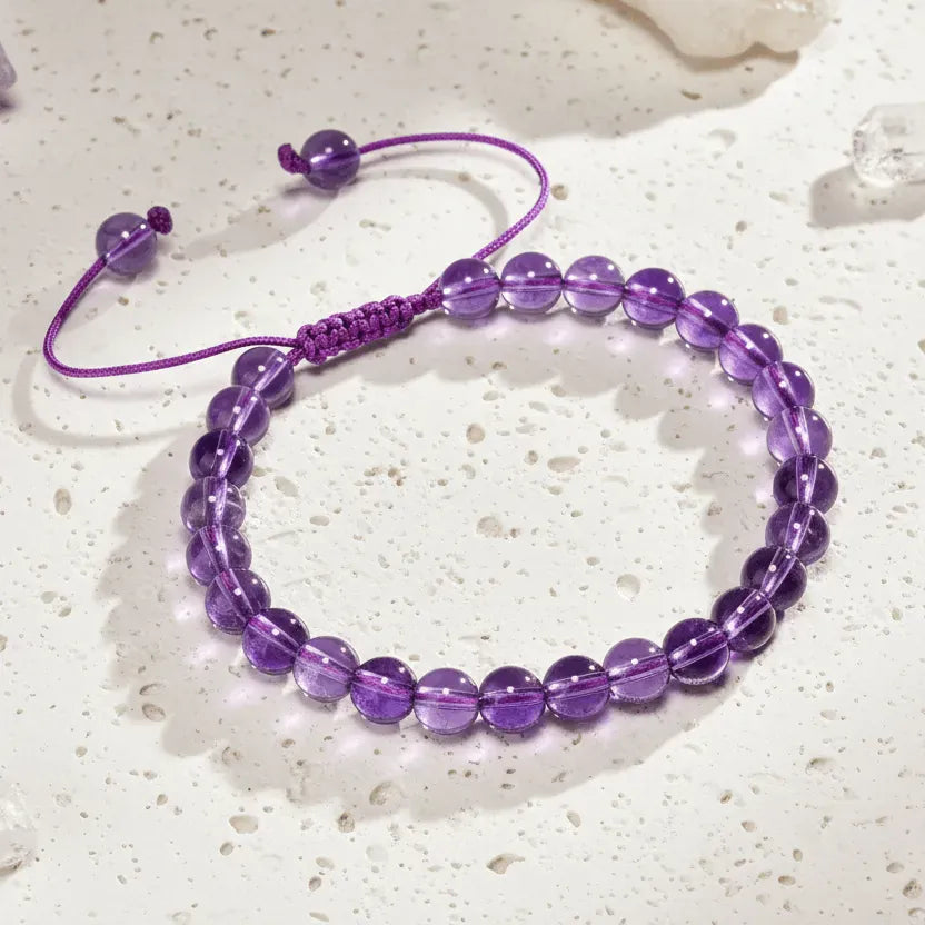 Purple beaded bracelet on a card with 'Amethyst' text on a wooden surface