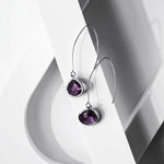 Purple gemstone earrings on a white background