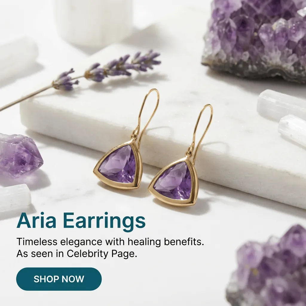 Gold earrings with purple gemstones on a white surface with crystals and lavender.