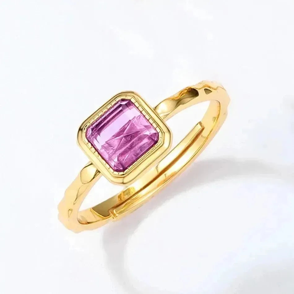 Gold ring with a pink gemstone on a white background