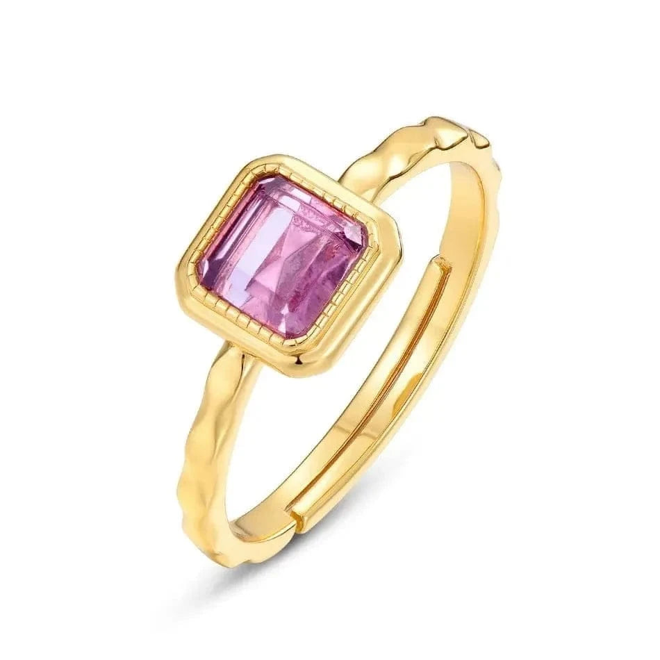 Gold ring with a pink gemstone on a white background
