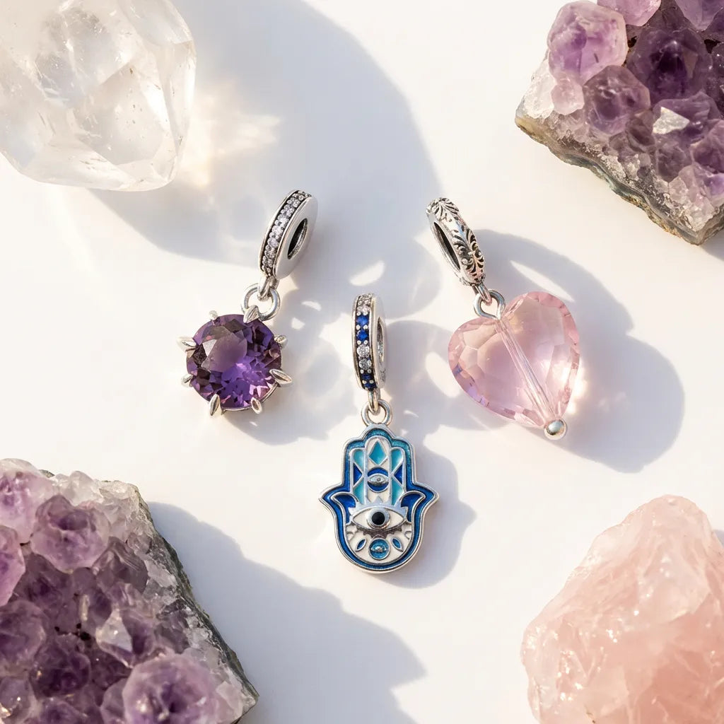 Three silver pendants with gemstones on a light background