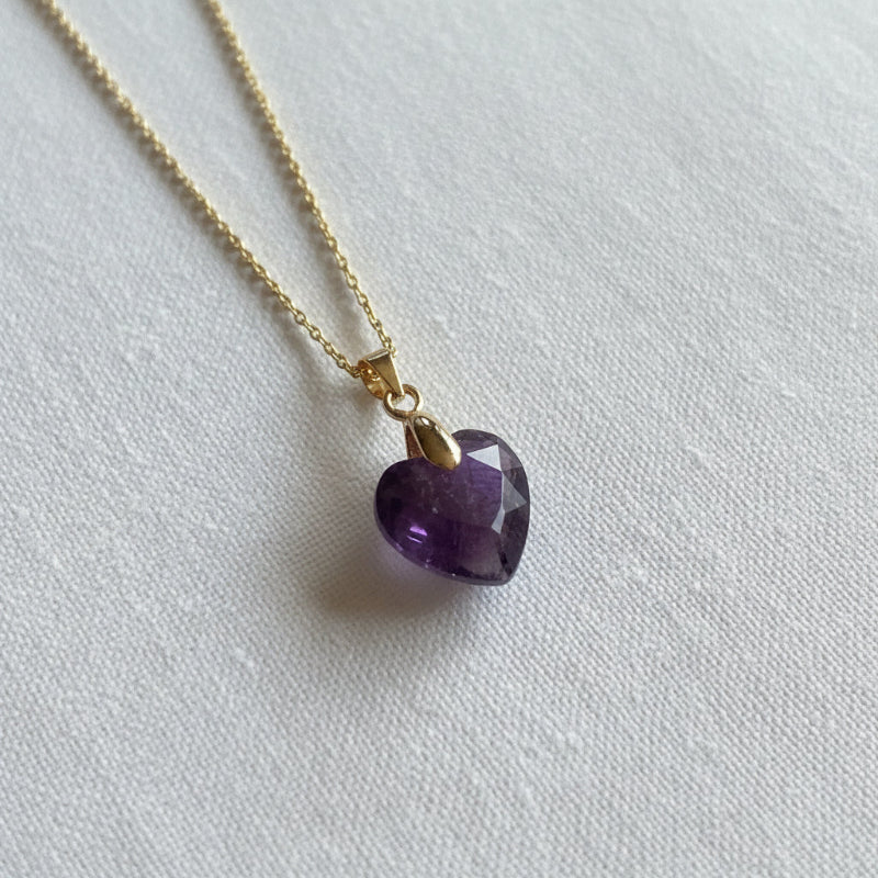 Close-up of gold plated wire-wrapped amethyst heart pendant, February birthstone jewelry