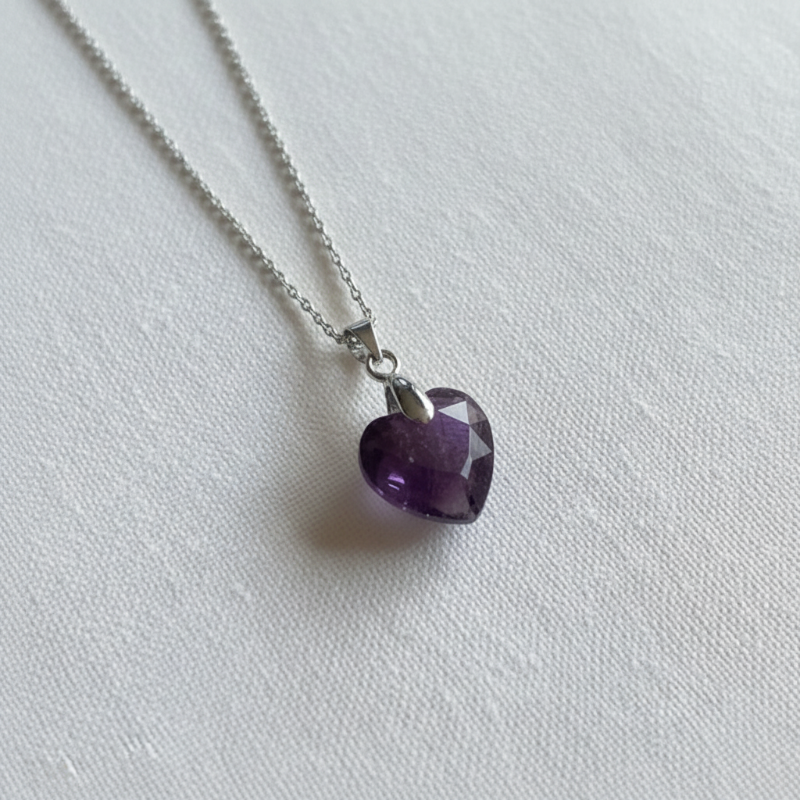 Close-up of silver plated wire-wrapped amethyst heart pendant, February birthstone jewelry