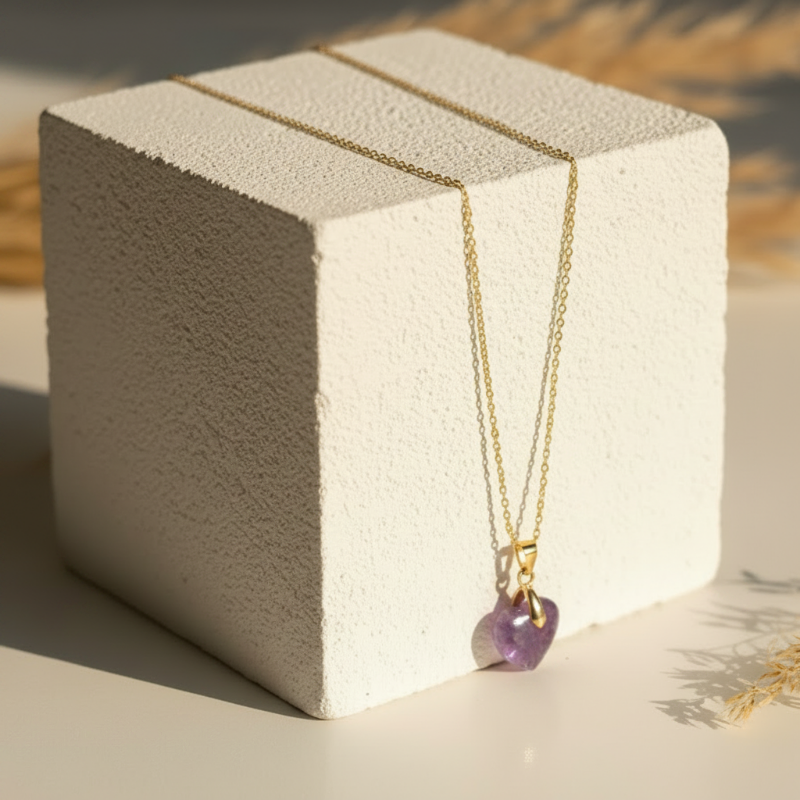 Amethyst heart pendant necklace displayed on a block, third eye chakra jewelry