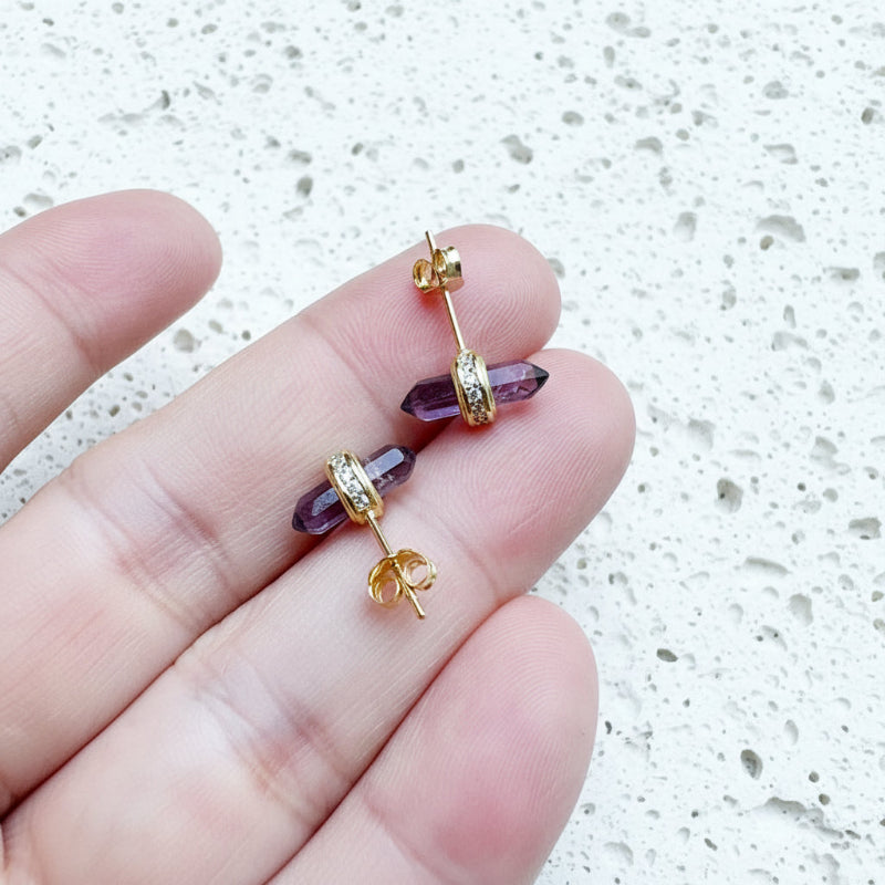 Gold amethyst hexagon stud earrings held in hand, third eye chakra jewelry