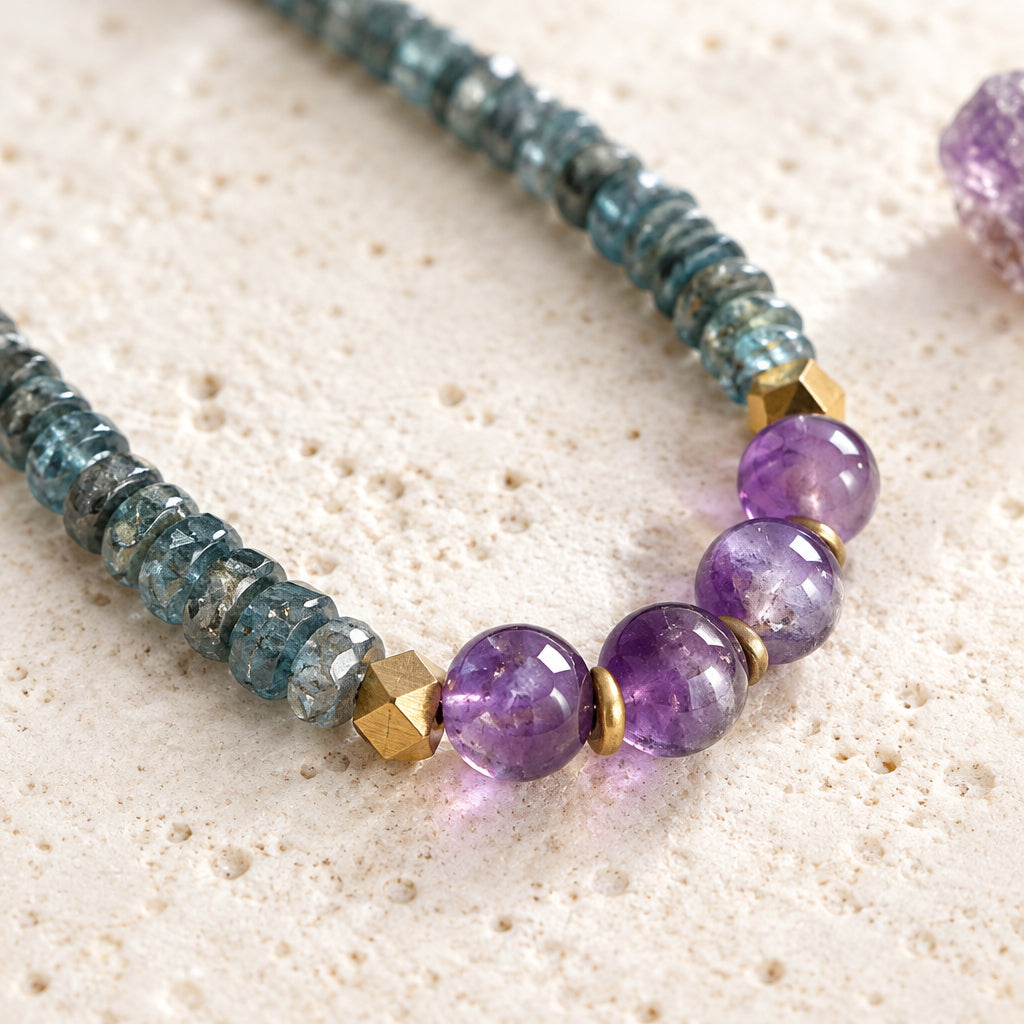 Close-up of faceted teal kyanite rondelles, round amethyst beads and hexagon brass beads