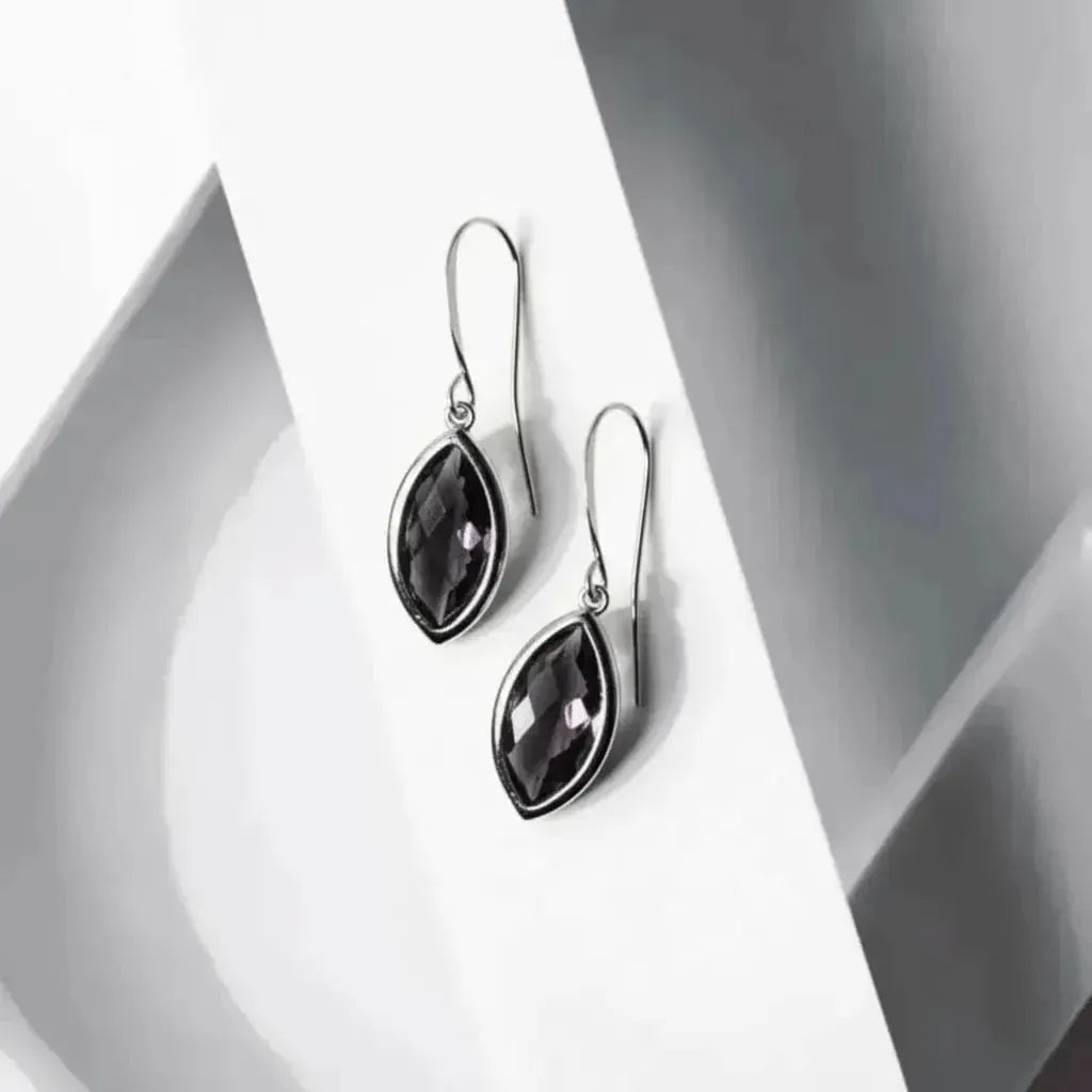 Pair of black teardrop earrings on a white background