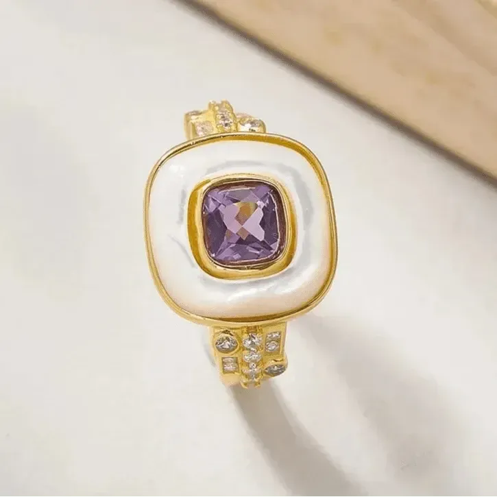 Gold ring with a purple gemstone on a light background, featuring the brand mystic soul jewelry