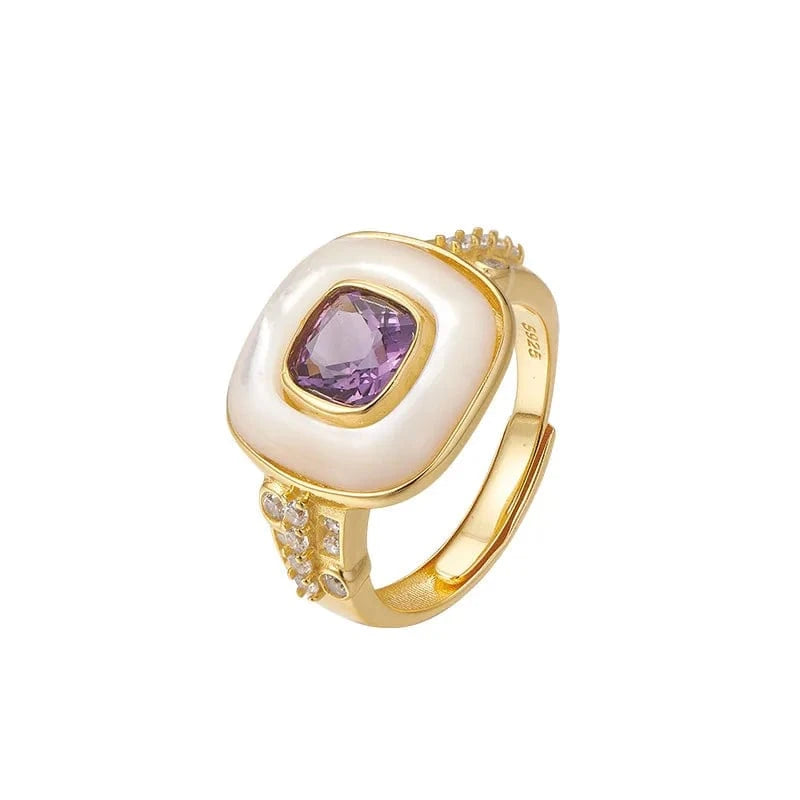 Gold ring with a purple gemstone on a white background